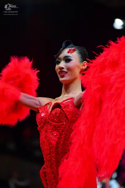 Dancesport competitor: Female dancer: red Latin dance dress, heavily embellished with red sequins and i