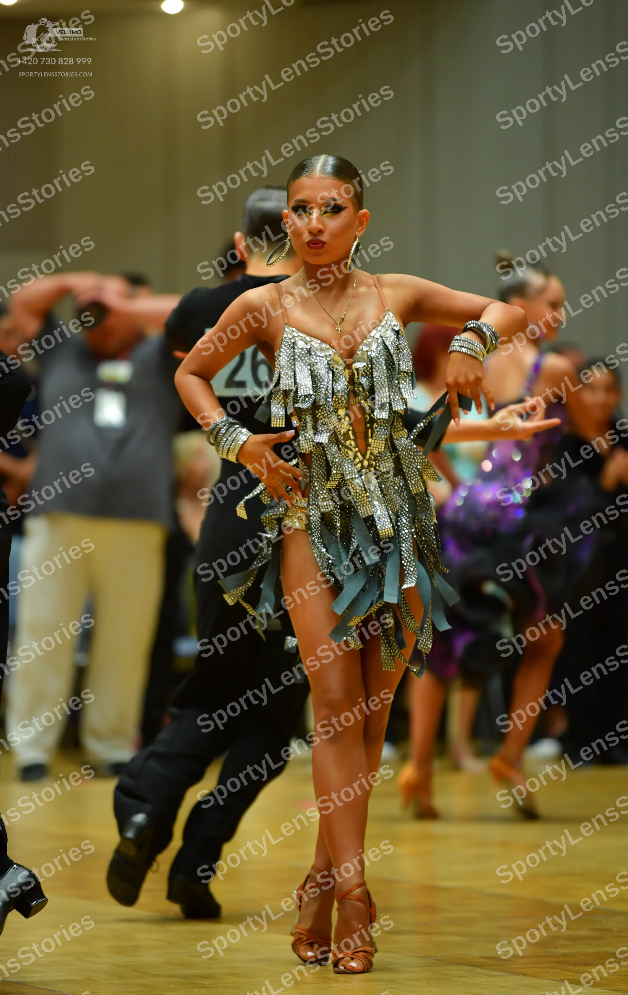 Dancesport competitor: Main female dancer: silver and light blue sequined Latin dress with fringe, wear