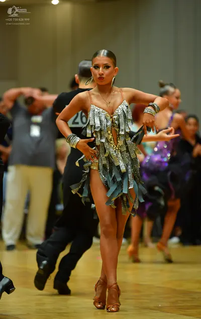 Dancesport competitor: Main female dancer: silver and light blue sequined Latin dress with fringe, wear