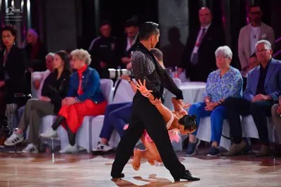 Dancesport competitor: Male dancer: black long-sleeved shirt with silver sequin pattern on the shoulder