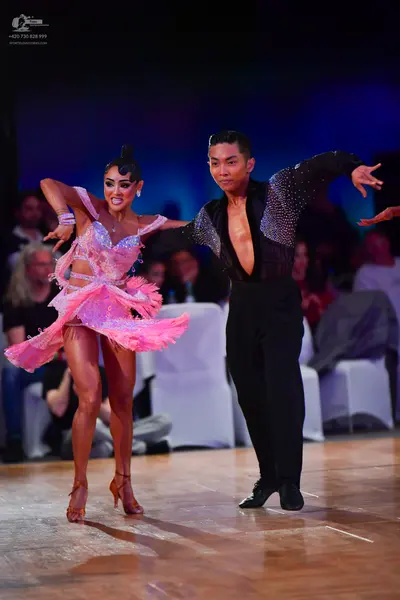 Dancesport competitor: Female dancer: pink latin dress with sequins and a layered, flared skirt