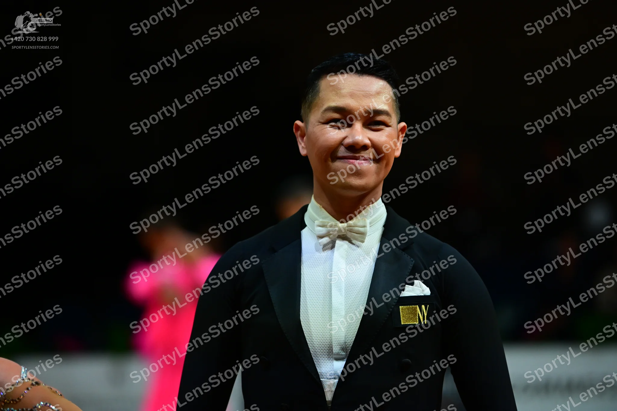 Dancesport competitor: Male dancer: black suit with a white shirt, white bow tie, and white pocket squa
