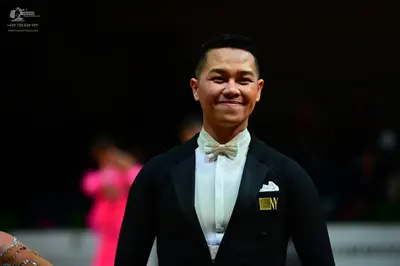 Dancesport competitor: Male dancer: black suit with a white shirt, white bow tie, and white pocket squa