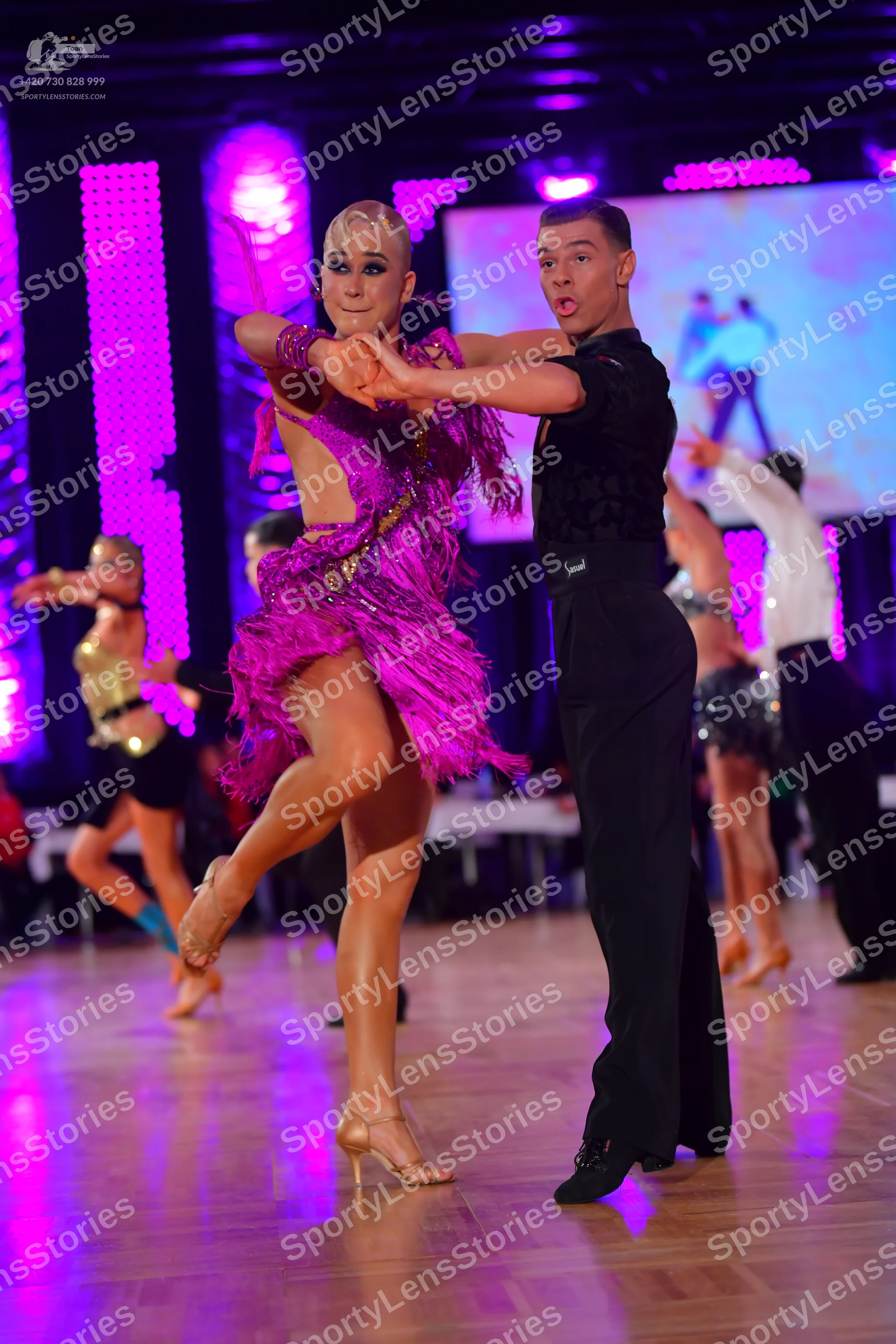 Dancesport competitor: Main female dancer: magenta Latin dress with fringe