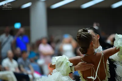 Dancesport competitor: Female dancer: pale cream/off-white dress with large ruffled fabric elements and