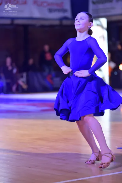 Dancesport competitor: Female dancer: blue long-sleeved dress with a full, flared skirt