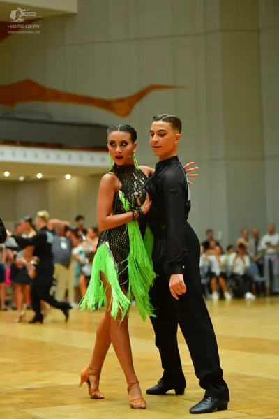 Dancesport competitor: Female dancer: black latin dress with lime green fringe and sequins