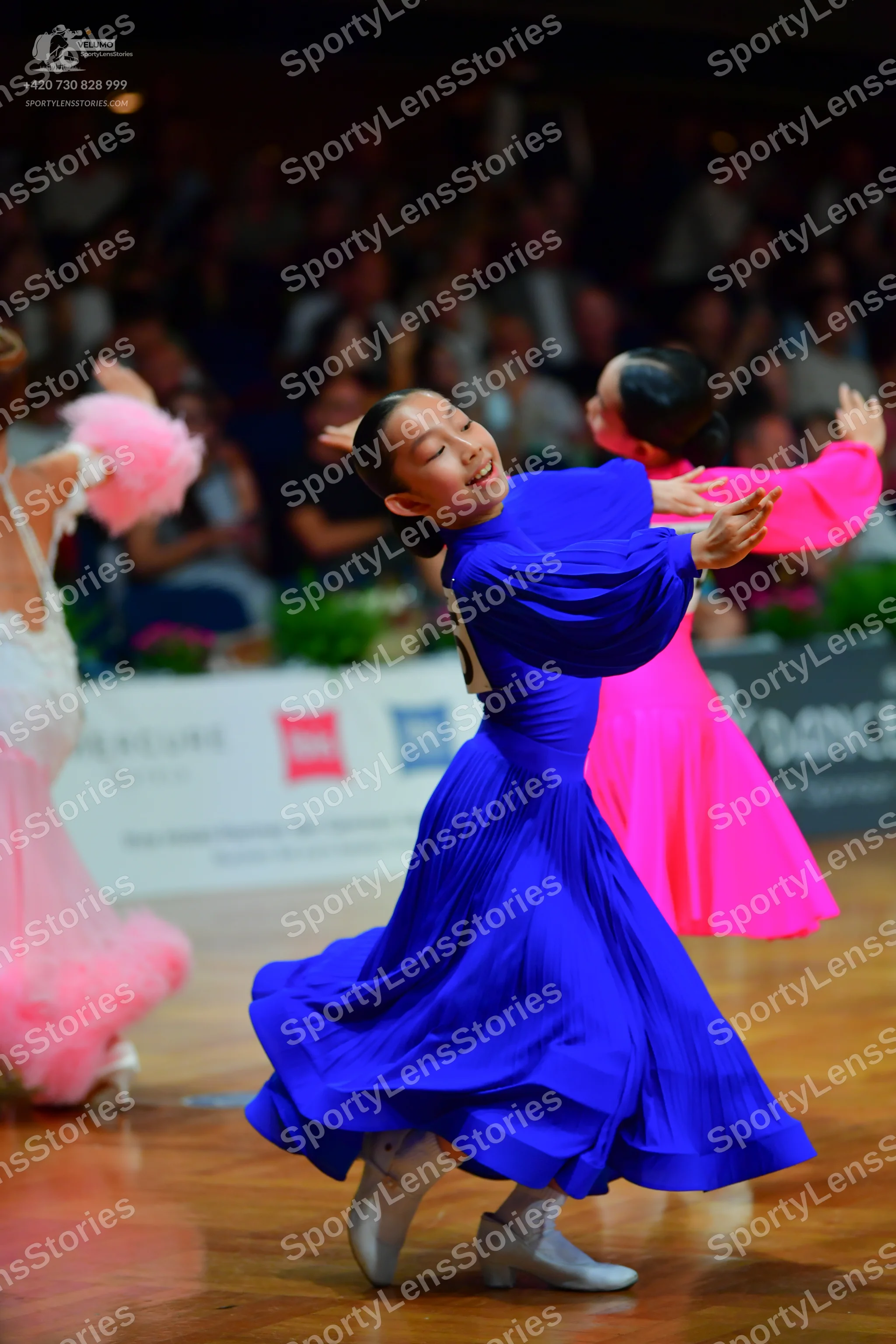 Dancesport competitor: Female dancer 1: white and light pink ballroom dress with a voluminous, ruffled