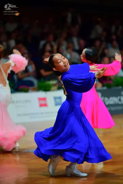 Dancesport competitor: Female dancer 1: white and light pink ballroom dress with a voluminous, ruffled 