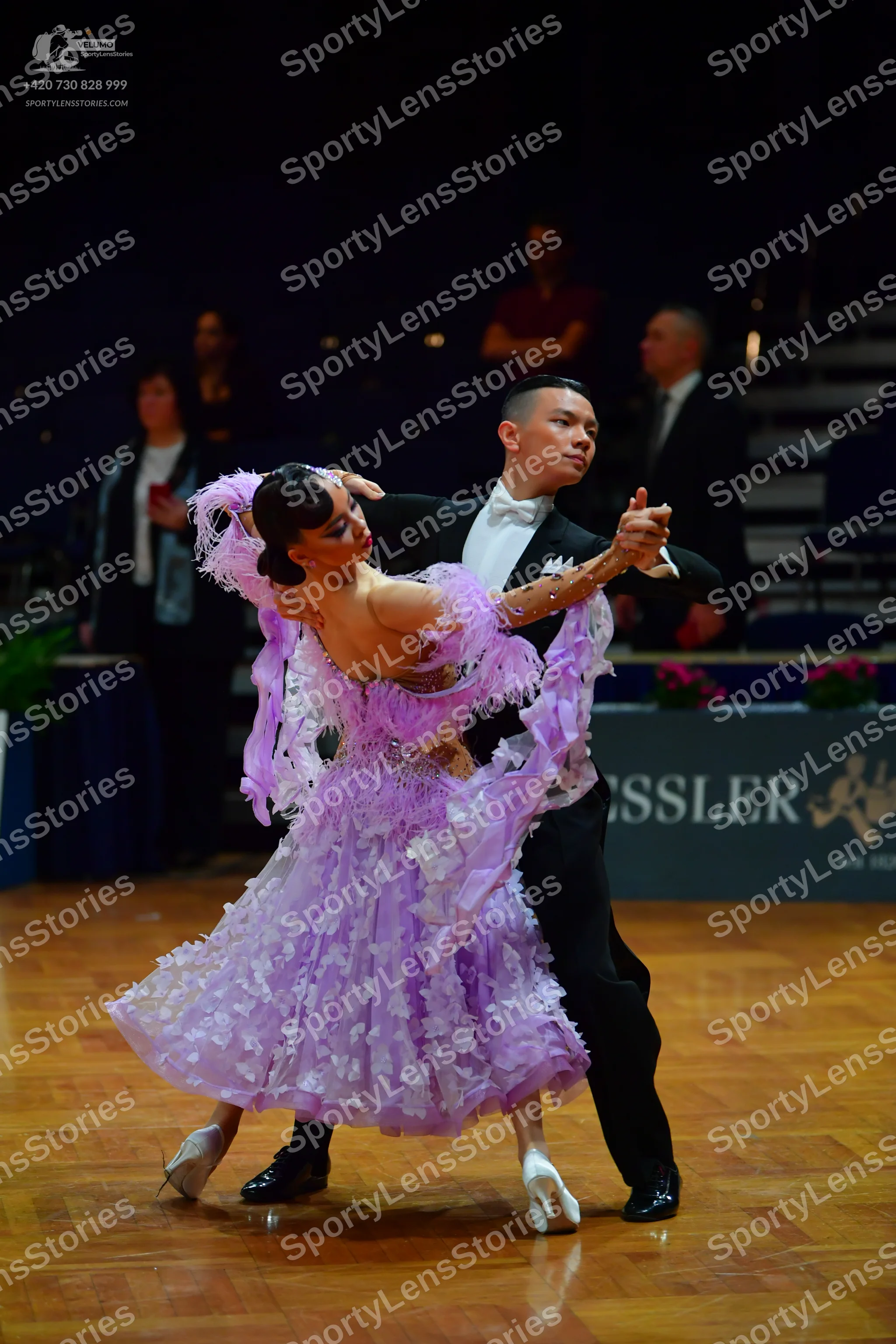 Dancesport competitor: Female dancer: voluminous light purple ballroom dress with many ruffles and laye