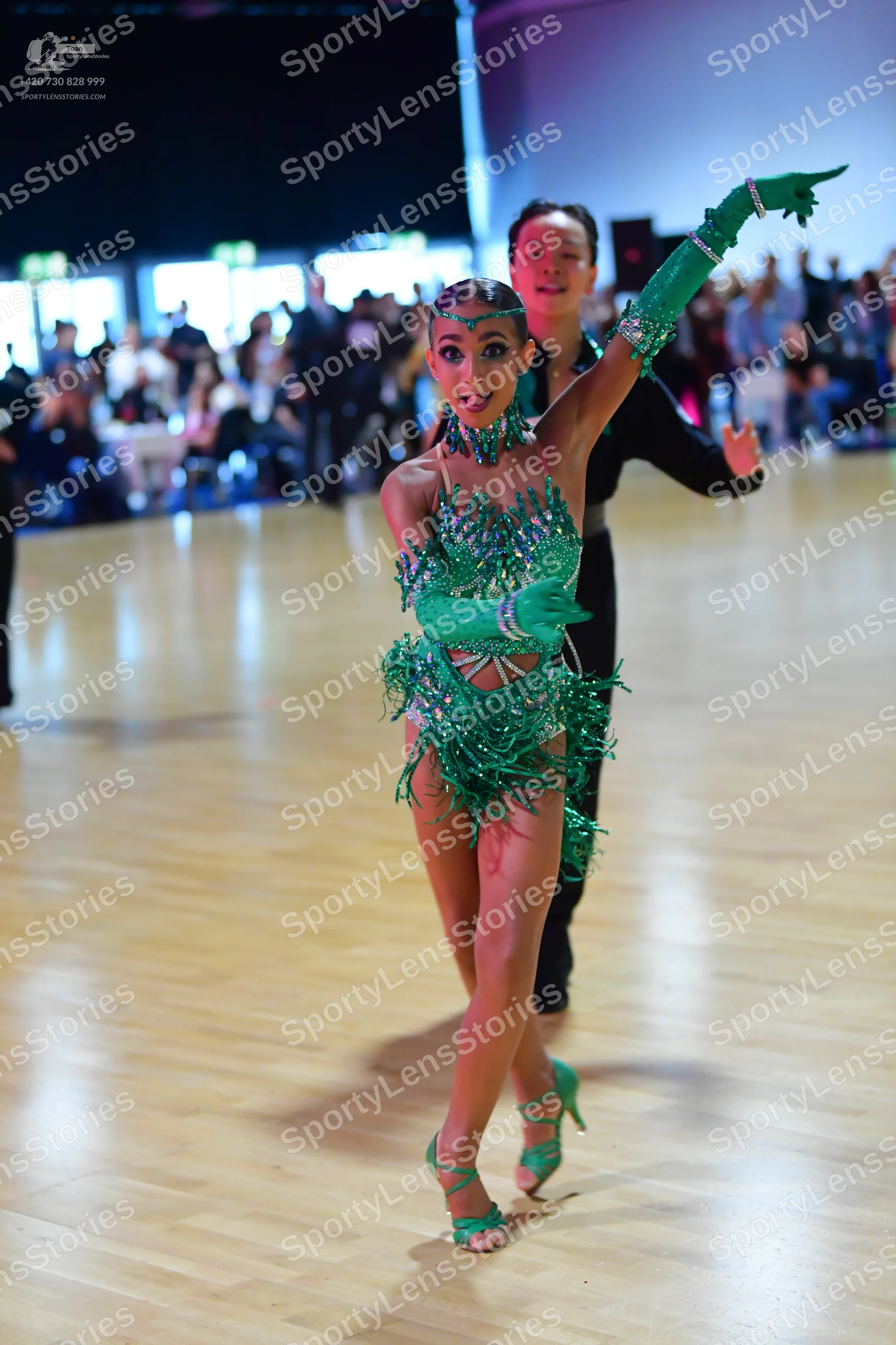 Dancesport competitor: Female dancer: green latin dance dress with sequins and fringe, matching green f