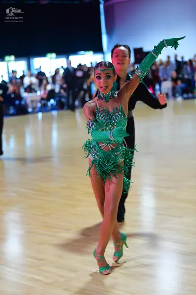 Dancesport competitor: Female dancer: green latin dance dress with sequins and fringe, matching green f