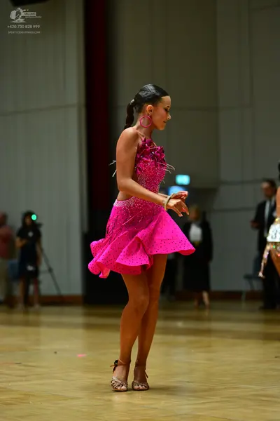 Dancesport competitor: Female dancer: pink latin dress with sequins, pink hoop earrings