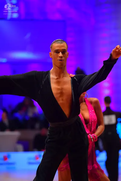Dancesport competitor: Male dancer: black long-sleeved shirt with deep V-neck and black trousers