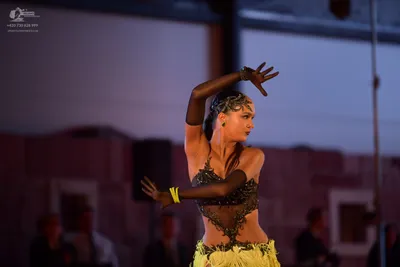 Dancesport competitor: Female dancer: dark lace and sequin Latin dance bodice with a bright yellow text