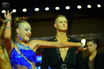 Dancesport competitor: Female dancer: blue Latin dance costume with sequins and long fringe, blue earri