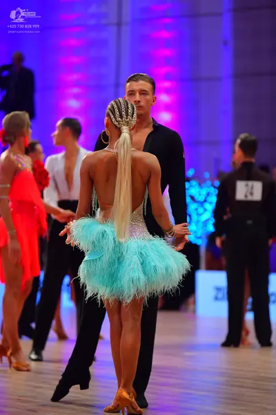 Dancesport competitor: Female dancer: light blue/aqua Latin dress with a feathery skirt
