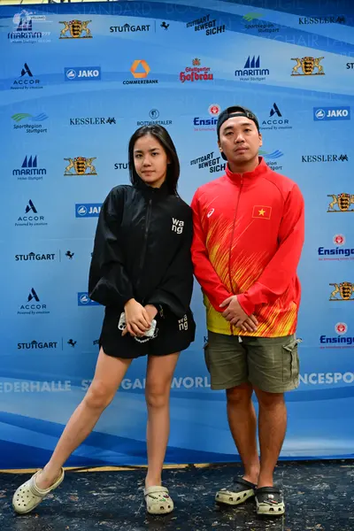 Dancesport competitor: Female dancer: black jacket and shorts with white "wang" lettering, and white cl