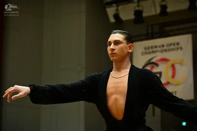Dancesport competitor: Male dancer: black long-sleeved, deep V-neck dance top with subtle shimmer/sequi