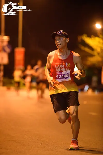 Marathon runner #42446: Runner 1: red and orange tank top with yellow bottom, black shorts, black cap, w