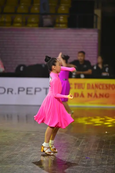 Dancesport competitor: Female dancer: pink long-sleeved dress in a solid color with smooth fabric