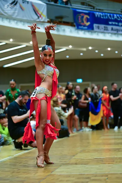 Dancesport competitor: Female dancer: red and silver/gold Latin dance costume with a sequined top, sequ