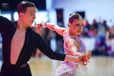 Dancesport competitor: Male dancer: black long-sleeved, low-cut Latin dance top