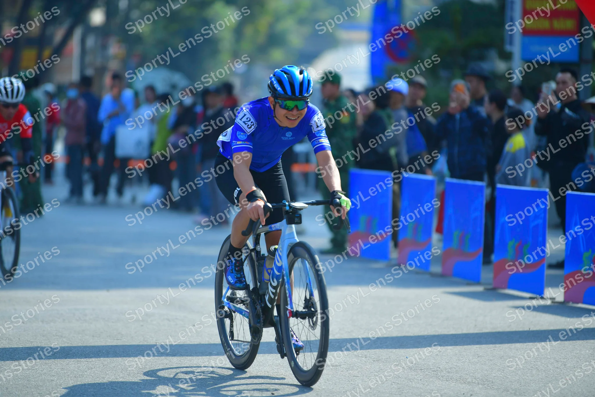 Cyclist: Cyclist 1: Blue and white jersey, black shorts, blue helmet