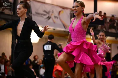 Dancesport competitor #15: Male dancer (left): black long-sleeved shirt with a deep V-neck and black trouse