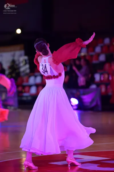 Dancesport competitor #34: Female dancer: white ballgown with large, red puffed sleeves and red ruffled det