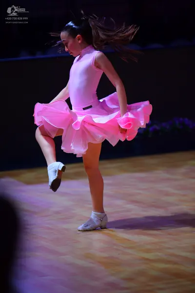 Dancesport competitor: Female dancer: light pink latin-style dress with a smooth, satin-like bodice and