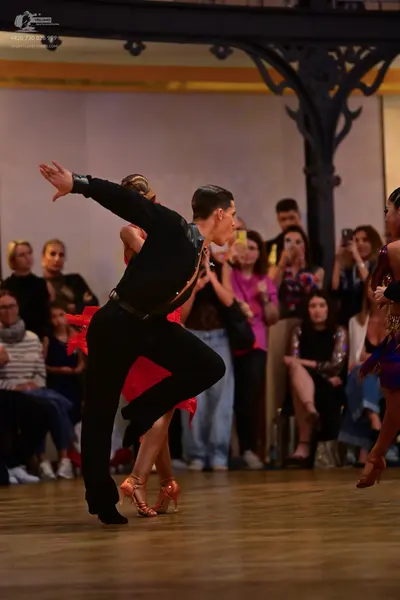 Dancesport competitor: Male dancer: black long-sleeved shirt and black trousers