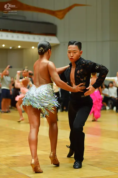Dancesport competitor: Male dancer: black long-sleeved shirt with lace pattern and black trousers
