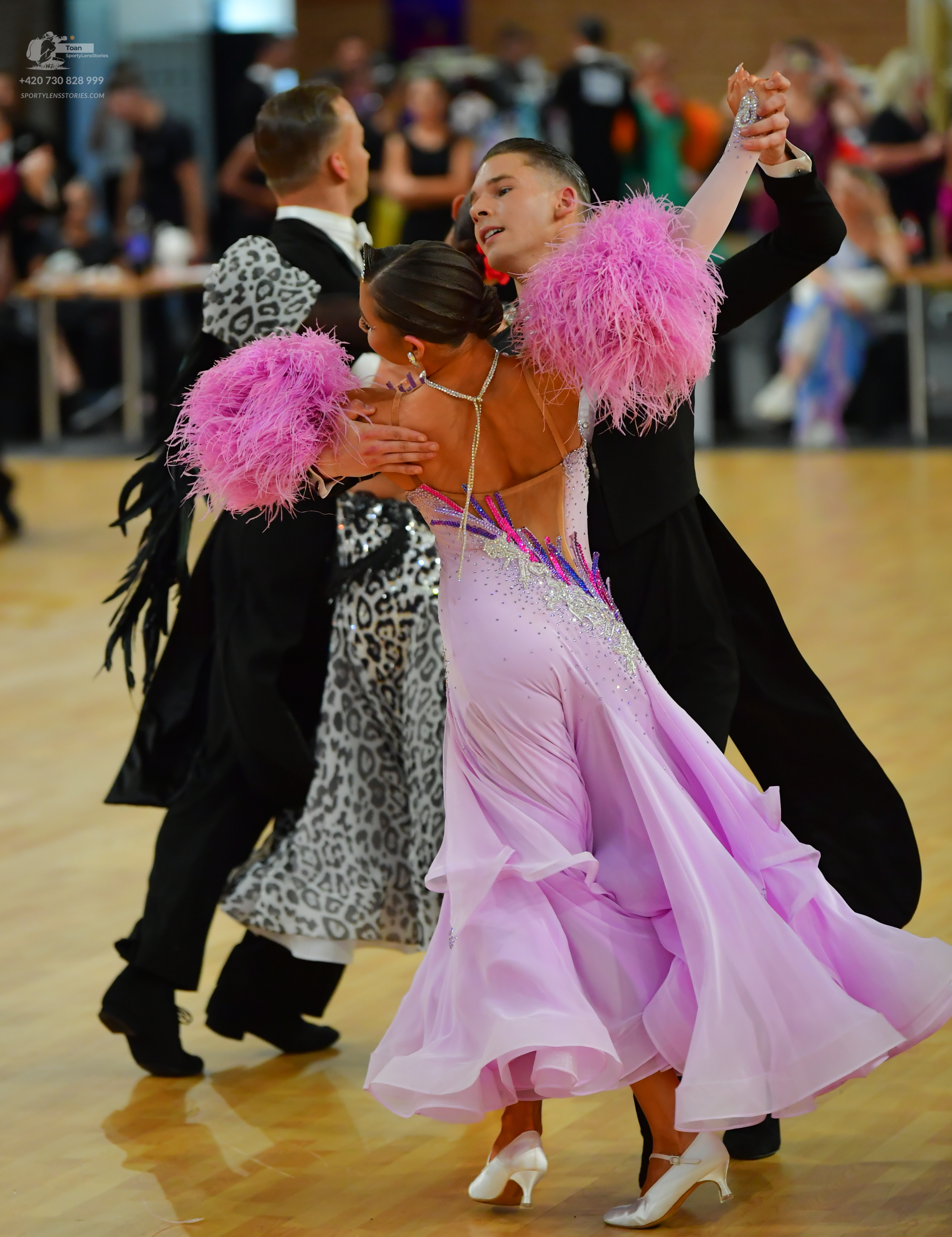 Dancesport competitor: ** Pink, full-length gown with a shimmering, slightly textured fabric (likely sa
