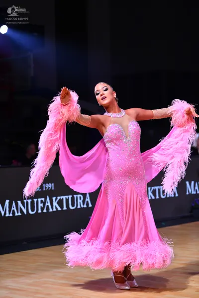 Dancesport competitor: Female dancer: pink ballroom dress with sequins on the bodice and large pink fea
