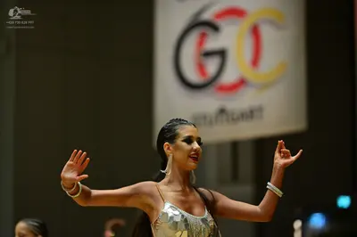 Dancesport competitor: Female dancer: silver sequin Latin dance dress with thin straps, accessorized wi