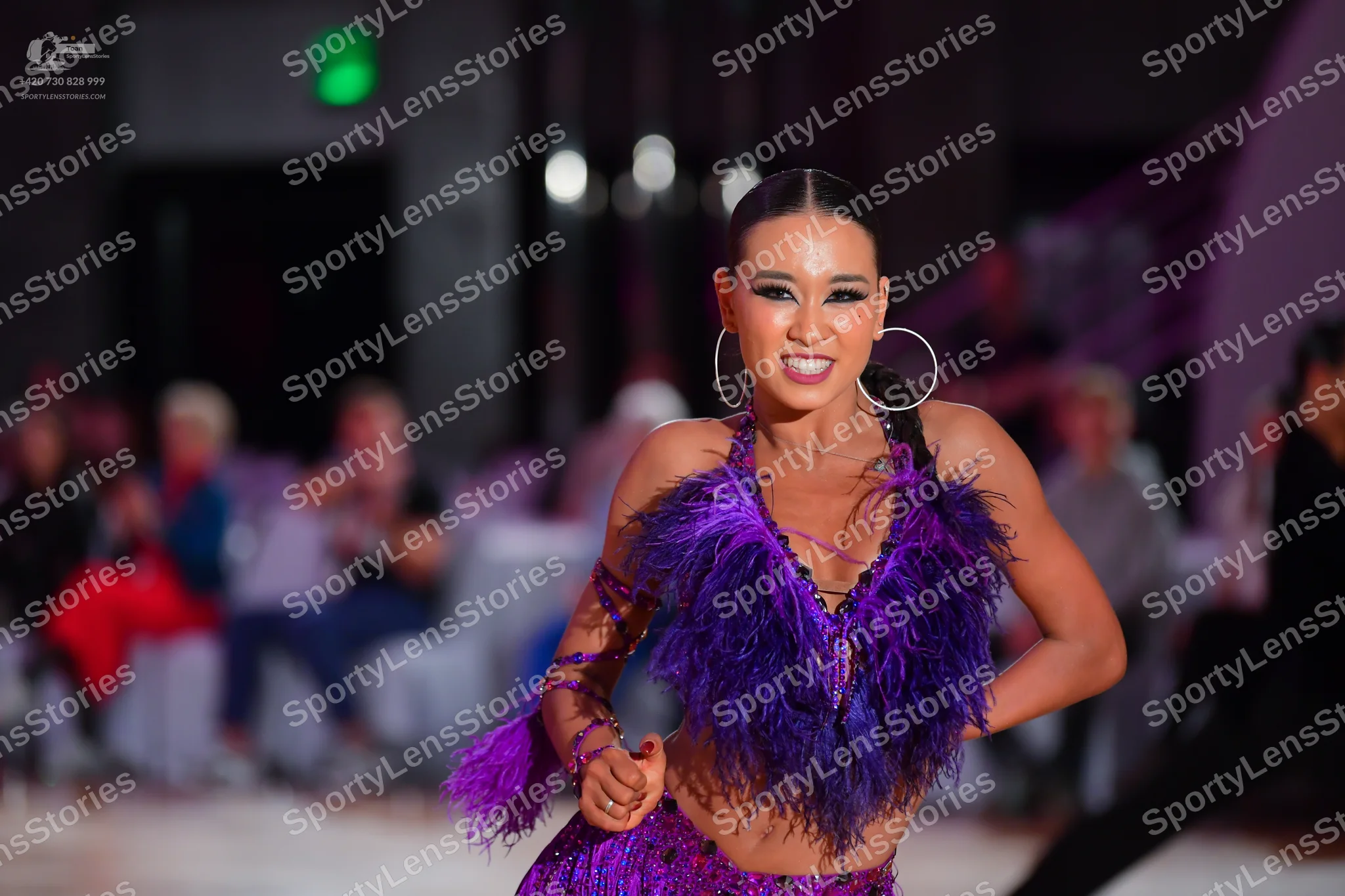 Dancesport competitor: Female dancer: purple latin costume with sequins and large purple feathers
