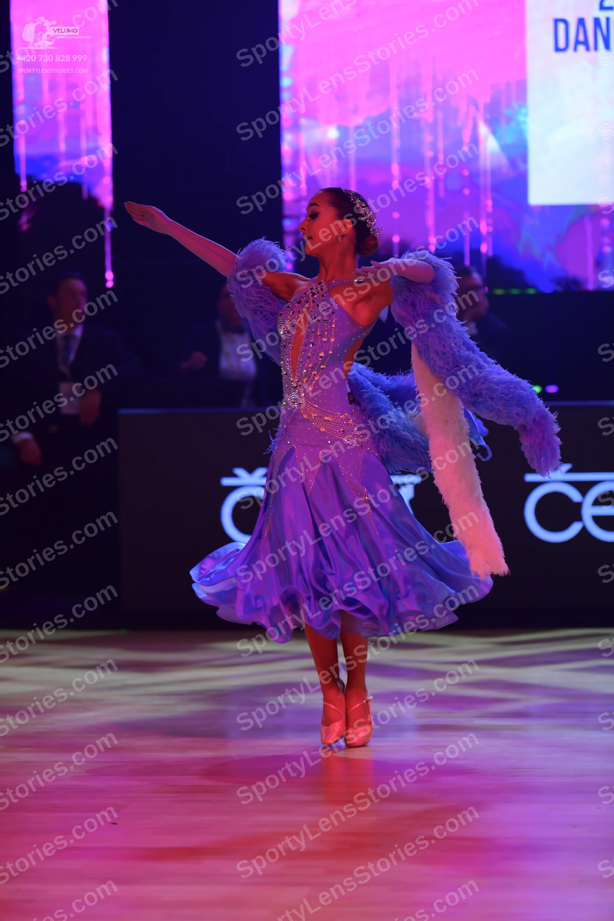 Dancesport competitor: Female dancer: light purple ballroom dress with a sequined bodice and a large, f