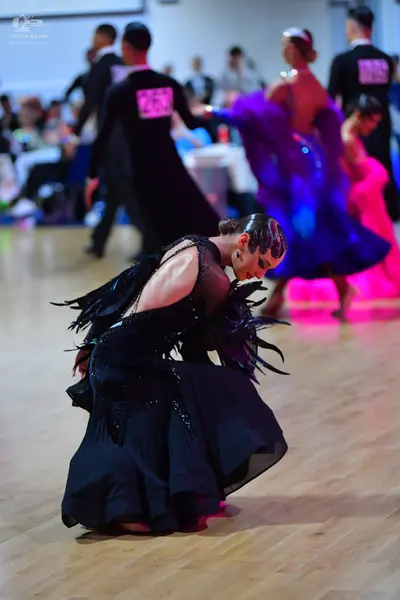 Dancesport competitor #725: Foreground female dancer: black ballroom dress with black feather-like fringe on