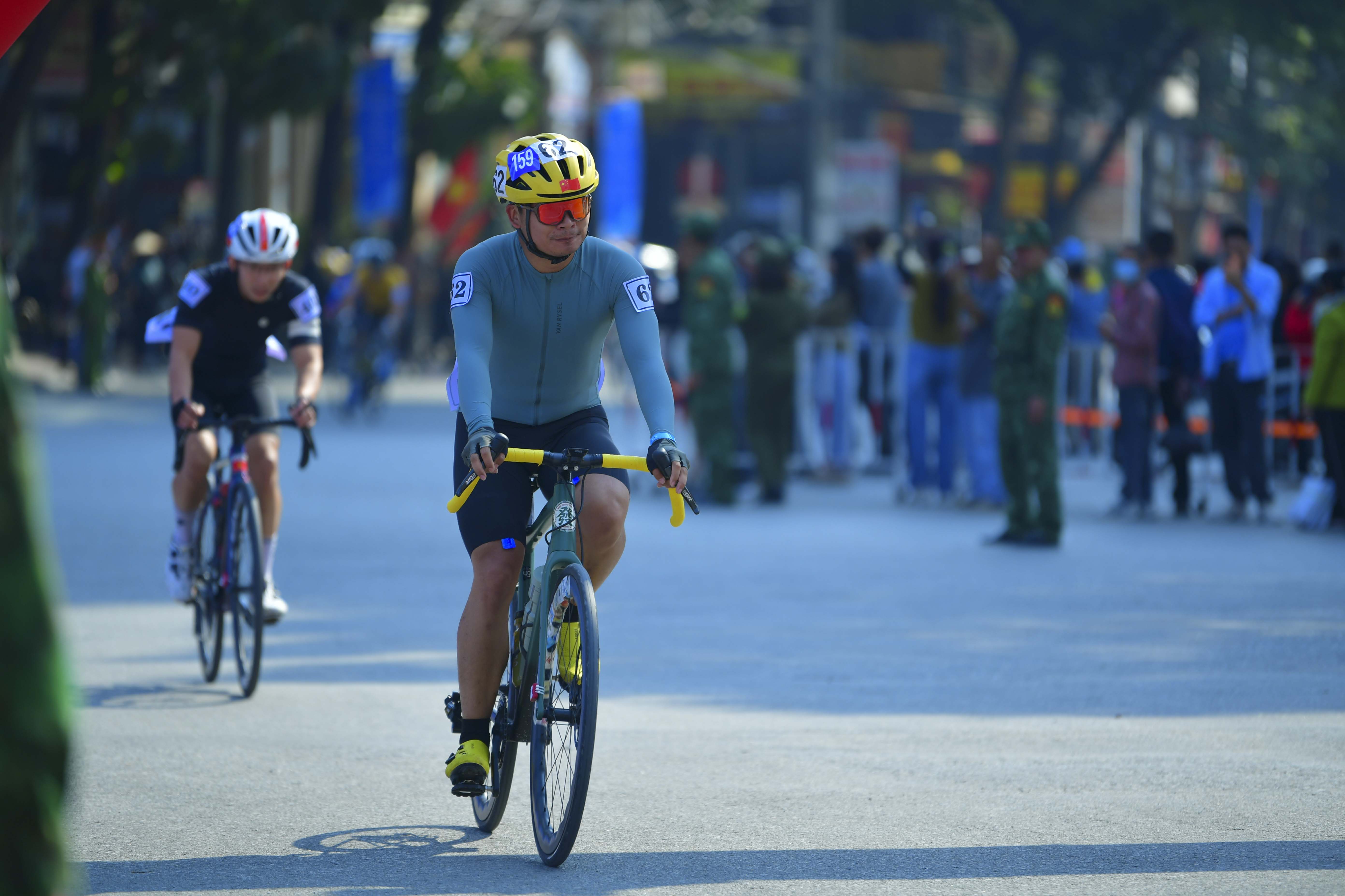 Cyclist #7159: Cyclist 1: Bright yellow jersey with black sleeves, black shorts
