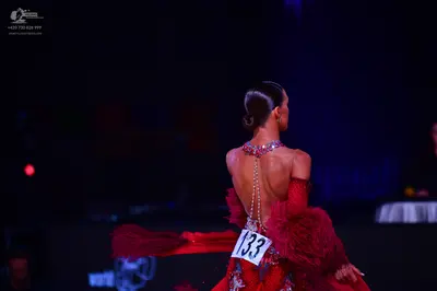Dancesport competitor: Female dancer: red latin dress with ruffled fabric and a beaded back detail