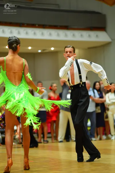 Dancesport competitor: Female dancer: bright lime green Latin dance dress with sequins and long fringe