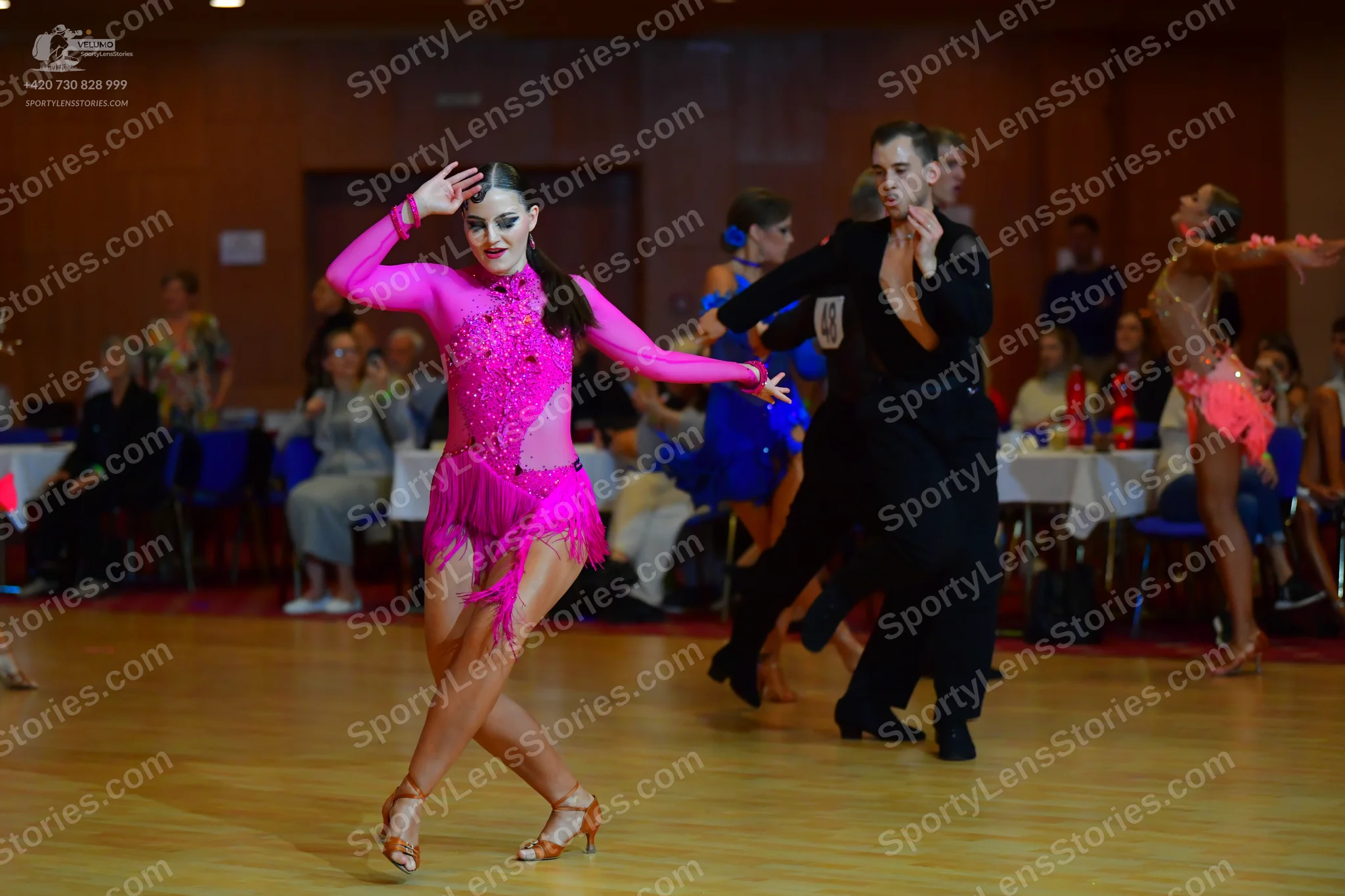 Dancesport competitor #110: Female dancer in foreground: bright pink latin dress with sequins and fringe on