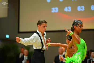 Dancesport competitor: Male dancer: white long-sleeved shirt with black straps and black trousers