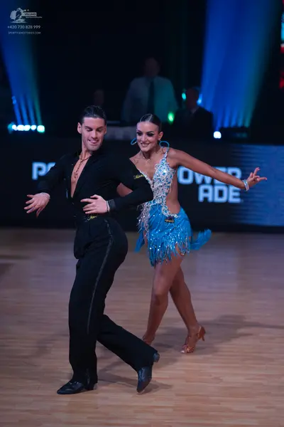 Dancesport competitor: Male dancer: black long-sleeved shirt and black trousers with a gold chain neckl
