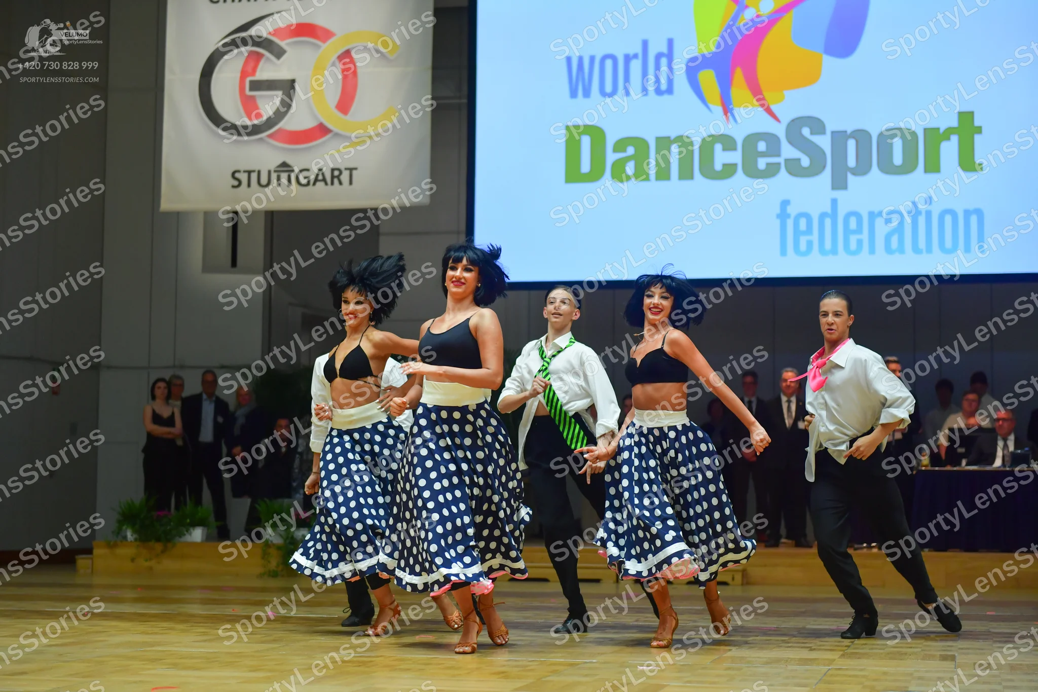 Dancesport competitor: Female dancer 1: black bra top and blue/white polka dot skirt