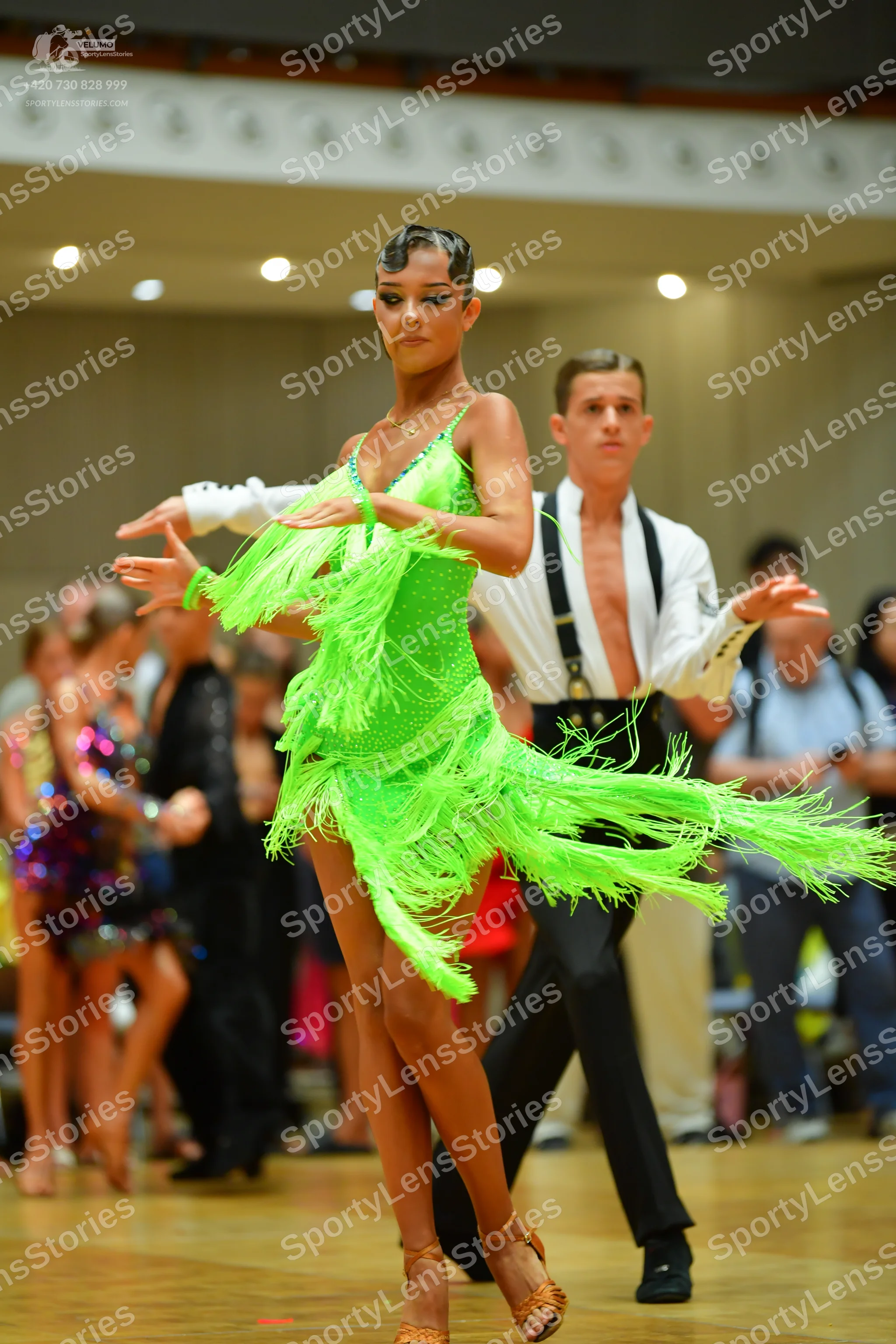 Dancesport competitor: Female dancer: neon green Latin dress with long fringe