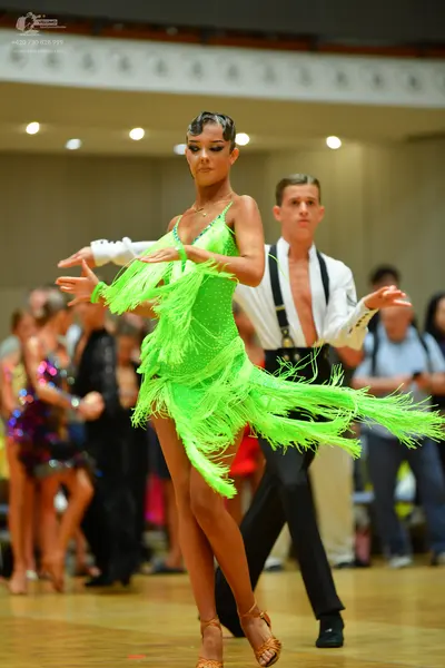 Dancesport competitor: Female dancer: neon green Latin dress with long fringe