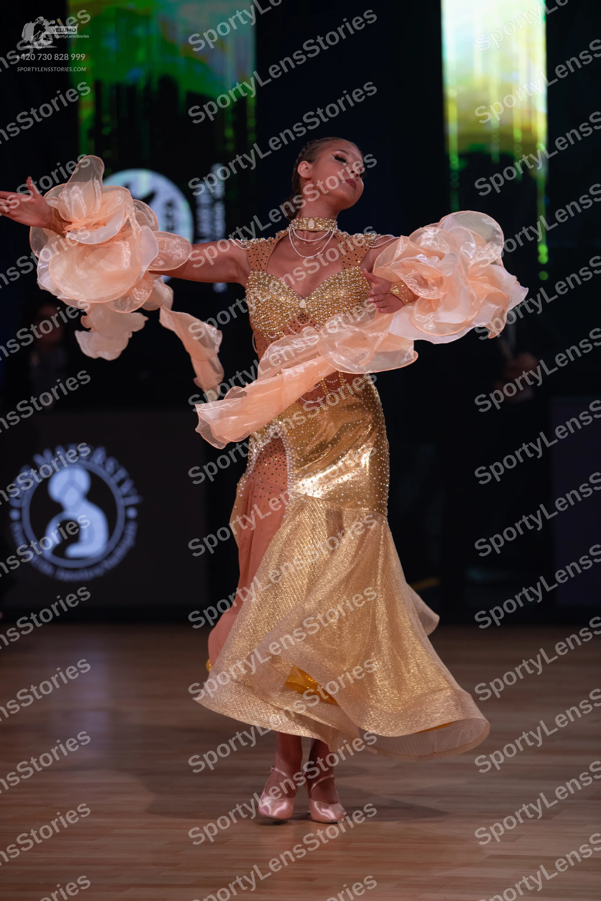Dancesport competitor: Female dancer: gold sequined ballroom dress with a high neckline and voluminous,