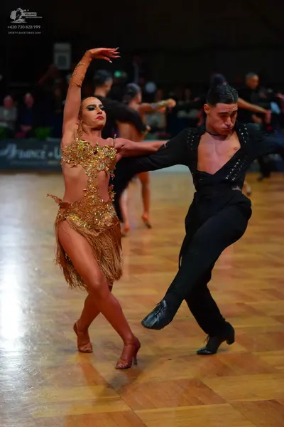 Dancesport competitor: Female dancer: gold latin dress with heavy sequin and crystal embellishments and